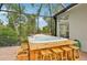 Beautifully screened-in patio with in-ground hot tub, bar seating and view of greenery at 6744 Hickory Hammock Cir, Bradenton, FL 34202