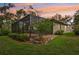 View of the home's exterior featuring a screened-in patio that enhances outdoor living in a lush, well-maintained backyard at 6744 Hickory Hammock Cir, Bradenton, FL 34202