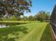 Lush backyard with well-manicured lawn and serene pond views, creating a private oasis at 6811 Honeysuckle Trl, Lakewood Ranch, FL 34202