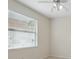 Bright bedroom features a ceiling fan and window with horizontal blinds at 6811 Honeysuckle Trl, Lakewood Ranch, FL 34202