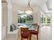 Cozy breakfast nook with a banquette seat, a glass table, and views of the screened-in pool at 6811 Honeysuckle Trl, Lakewood Ranch, FL 34202