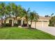 Inviting home featuring a tile roof, a well-manicured lawn, palm trees, and a three-car garage at 6811 Honeysuckle Trl, Lakewood Ranch, FL 34202