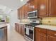 Close-up of a kitchen showcasing wood cabinets, stainless steel appliances and light countertops at 6811 Honeysuckle Trl, Lakewood Ranch, FL 34202