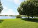 Scenic lake view framed by mature trees and manicured lawns, creating a serene outdoor setting at 6811 Honeysuckle Trl, Lakewood Ranch, FL 34202