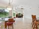 Open living space with a large window overlooking the pool and a tray ceiling with fan at 6811 Honeysuckle Trl, Lakewood Ranch, FL 34202