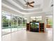 Bright living area features a wall of windows overlooking the pool and a ceiling fan at 6811 Honeysuckle Trl, Lakewood Ranch, FL 34202