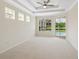 A spacious main bedroom offering a tray ceiling, a neutral palette, and access to the pool area at 6811 Honeysuckle Trl, Lakewood Ranch, FL 34202