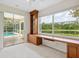 Bright home office with a built-in desk, shelving, and a screened-in porch and pool area at 6811 Honeysuckle Trl, Lakewood Ranch, FL 34202