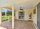 Covered patio featuring brick flooring, a ceiling fan, and views of the lush outdoor landscape at 6811 Honeysuckle Trl, Lakewood Ranch, FL 34202