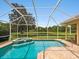 A screened-in pool with a pond view and tile spa at 6811 Honeysuckle Trl, Lakewood Ranch, FL 34202