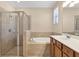 Inviting bathroom with glass-enclosed shower, soaking tub, and double vanity with wooden cabinetry at 7140 Marsh View Ter, Bradenton, FL 34212