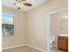 Comfortable bedroom with natural light, featuring tile floors, a ceiling fan, and an ensuite bathroom at 7140 Marsh View Ter, Bradenton, FL 34212