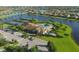 Aerial view showcases a community clubhouse, pool, tennis courts, and scenic lake views at 7140 Marsh View Ter, Bradenton, FL 34212