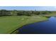 Scenic aerial view of a well-maintained golf course next to a tranquil lake surrounded by lush greenery at 7140 Marsh View Ter, Bradenton, FL 34212