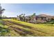 An outdoor pool with screened enclosure and serene backyard is enhanced by palm trees and waterfront views at 7140 Marsh View Ter, Bradenton, FL 34212