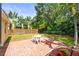 Cozy backyard patio features a white table and chairs, surrounded by lush landscaping for relaxing outdoor enjoyment at 743 Stonecrest Dr, Sarasota, FL 34232