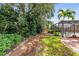 Well-maintained backyard featuring lush greenery and a screened-in pool area with tropical landscaping at 743 Stonecrest Dr, Sarasota, FL 34232
