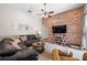 Cozy living room features brick accent wall, comfortable couches, and ceiling fan at 743 Stonecrest Dr, Sarasota, FL 34232