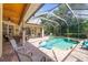 Inviting screened-in pool area features a spa, sun shelf, and brick pavers, perfect for outdoor relaxation at 743 Stonecrest Dr, Sarasota, FL 34232