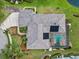 Overhead view of home with screen enclosed pool, solar panels, manicured landscaping, and three car garage at 7513 Coventry Ct, Lakewood Ranch, FL 34202