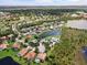 An aerial view displays a neighborhood with homes surrounding ponds and lush green spaces at 7513 Coventry Ct, Lakewood Ranch, FL 34202