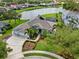 Picturesque aerial view of a home with a lake view, three-car garage, and lush landscaping at 7513 Coventry Ct, Lakewood Ranch, FL 34202