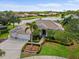 Aerial view of a single-Gathering home featuring tropical landscaping, three-car garage and waterfront backyard at 7513 Coventry Ct, Lakewood Ranch, FL 34202