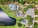 A high-angle aerial view showcases three elegant homes bordering a pond and lush green spaces at 7513 Coventry Ct, Lakewood Ranch, FL 34202