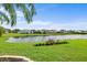 A picturesque view showcases a lush backyard, serene pond, and a row of elegant homes at 7513 Coventry Ct, Lakewood Ranch, FL 34202
