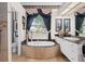 A luxurious bathroom featuring a jetted tub, elegant fixtures, and a window providing natural light at 7513 Coventry Ct, Lakewood Ranch, FL 34202