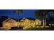 Stunning home exterior at night with lush landscaping, lighting and stately curb appeal at 7513 Coventry Ct, Lakewood Ranch, FL 34202