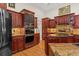 Kitchen showcasing stainless steel appliances, wood cabinets, and tile backsplash at 7513 Coventry Ct, Lakewood Ranch, FL 34202