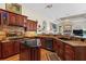 Elegant kitchen boasts custom wood cabinetry, granite countertops, an island, and seamlessly flows into the living space at 7513 Coventry Ct, Lakewood Ranch, FL 34202
