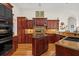 Kitchen boasts dark wood cabinets, tile backsplash, recessed lighting, and island at 7513 Coventry Ct, Lakewood Ranch, FL 34202