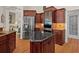 Kitchen with stainless steel appliances and an island featuring a black countertop at 7513 Coventry Ct, Lakewood Ranch, FL 34202