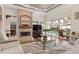 Open living room with fireplace, ceiling fan, and view of pool through sliding glass doors at 7513 Coventry Ct, Lakewood Ranch, FL 34202