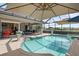 Inviting screened-in pool area with covered seating, a ceiling fan, and a view of the beautiful backyard at 7513 Coventry Ct, Lakewood Ranch, FL 34202