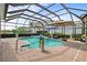 Screened in pool area with brick patio, lush landscaping, and a covered seating area at 7513 Coventry Ct, Lakewood Ranch, FL 34202
