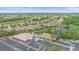 Aerial view of community buildings with parking, set amongst homes, lakes and a golf course at 8382 Creekview Ln, Englewood, FL 34224