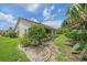 Home exterior showing a beautiful backyard, lush landscaping, and patio at 8382 Creekview Ln, Englewood, FL 34224