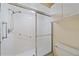 Bright bathroom featuring a shower with glass sliding doors and tile surround at 8382 Creekview Ln, Englewood, FL 34224