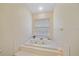 Relaxing bathroom with a luxurious soaking tub and natural light from the window at 8382 Creekview Ln, Englewood, FL 34224