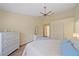 Bright bedroom with ceiling fan, closet, ensuite access, and stylish decor at 8382 Creekview Ln, Englewood, FL 34224