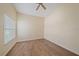 Empty room featuring wood-look floors, neutral walls, large window, and a ceiling fan at 8382 Creekview Ln, Englewood, FL 34224