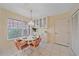 Charming dining area with a unique light fixture, built-in display cabinets, and a convenient entry door at 8382 Creekview Ln, Englewood, FL 34224