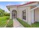 Charming front entrance with well-maintained landscaping and a screened doorway at 8382 Creekview Ln, Englewood, FL 34224