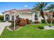 Charming single-story home featuring a red tile roof, lush landscaping, and well-manicured lawn at 8382 Creekview Ln, Englewood, FL 34224
