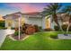 Charming single-story home featuring a red tile roof, lush landscaping, and well-manicured lawn at 8382 Creekview Ln, Englewood, FL 34224