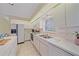 Bright kitchen featuring white cabinetry, tile backsplash, and stainless-steel appliances at 8382 Creekview Ln, Englewood, FL 34224