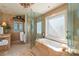 Elegant bathroom with a chandelier, marble tub, vanity, and separate glass shower at 845 Longboat Club Rd, Longboat Key, FL 34228